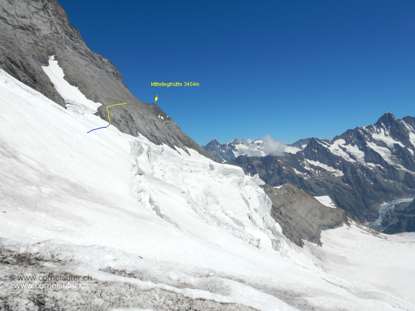 Der Einstieg befindet sich bei der zweiten Schneezunge die fast direkt unterhalb des Grossen Turms ist, Achtung auf die Längsspalten, Steine im Schnee zeugen von Steinschlag. Über die Felsen Östlich dieser Schneezunge hinauf klettern, 3b, Haken, Muniringe.