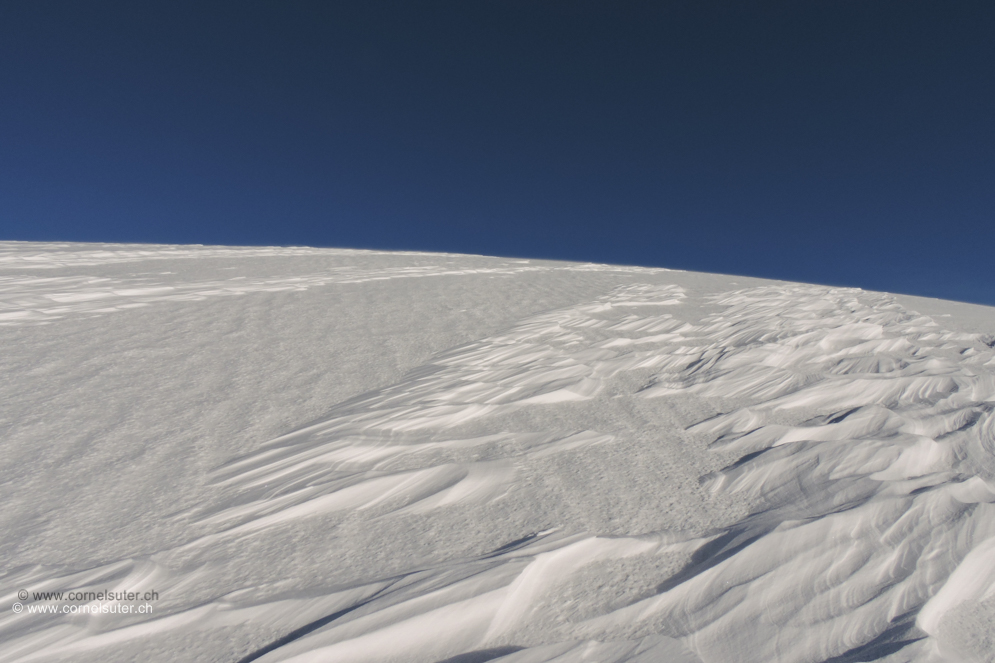 Etwas weiter oben in Richtung Gipfel gross Flächig bis auf den Altschnee abgeblasen, Windgangeln.